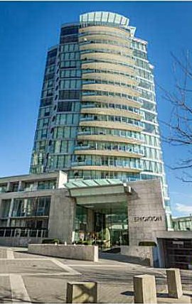 A curved glass condominium tower on the Yaletown seawall