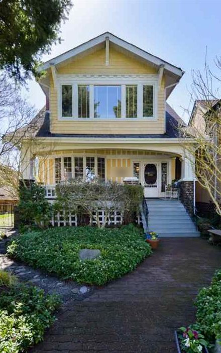 A restored Craftsman home behind a spring garden in Kitsilano